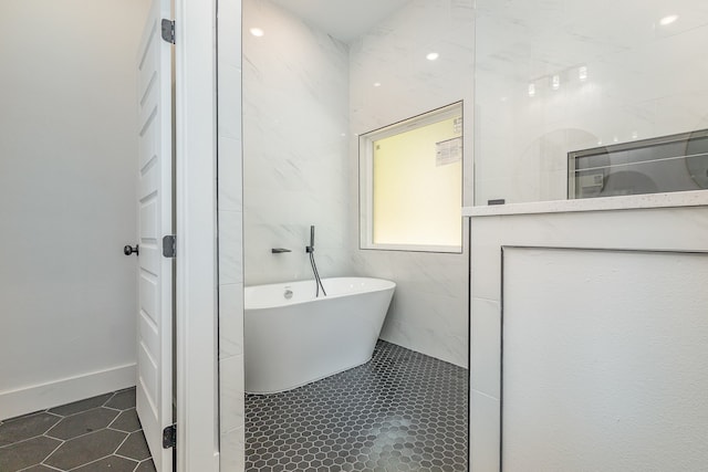 bathroom featuring tile walls and a bathtub