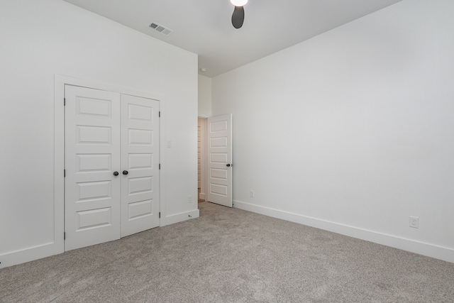 unfurnished bedroom featuring light carpet, a closet, and ceiling fan