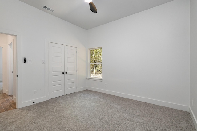 unfurnished bedroom featuring baseboards, a closet, visible vents, and carpet flooring