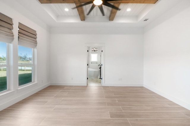 spare room with ceiling fan, a wealth of natural light, light hardwood / wood-style floors, and beamed ceiling