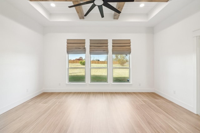 empty room with beam ceiling, ceiling fan, and light wood-type flooring