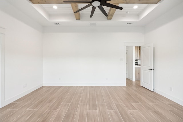 unfurnished room with a raised ceiling and light hardwood / wood-style flooring