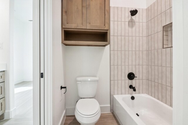 full bathroom with vanity, toilet, wood-type flooring, and tiled shower / bath