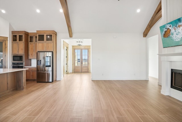 kitchen featuring french doors, stainless steel appliances, an inviting chandelier, vaulted ceiling with beams, and light hardwood / wood-style floors