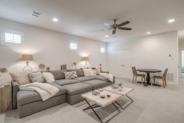 living room featuring light carpet, a healthy amount of sunlight, and ceiling fan