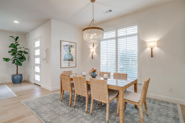 dining area featuring light hardwood / wood-style flooring and an inviting chandelier