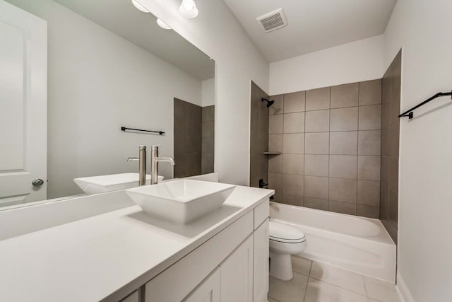 full bathroom featuring tile patterned flooring, vanity, tiled shower / bath combo, and toilet