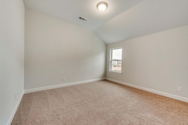 spare room with lofted ceiling and carpet flooring