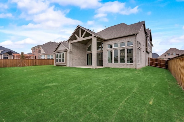 2802 Chandler Ct, Mansfield, TX 76063 - rear view of house featuring a lawn, a fenced backyard, brick siding, and roof with shingles