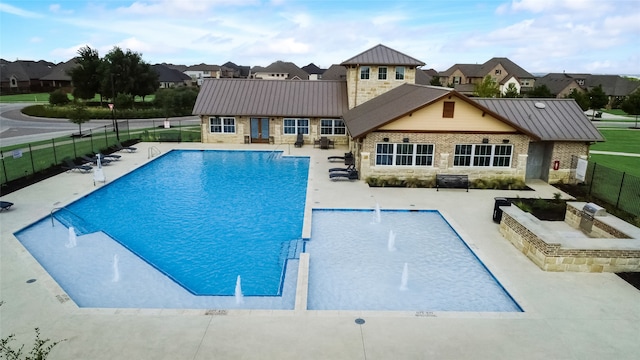 view of swimming pool with pool water feature and a patio area