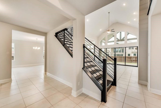 stairway featuring tile patterned flooring, ceiling fan with notable chandelier, and high vaulted ceiling