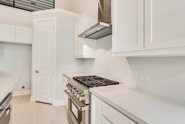 kitchen with white cabinetry, light tile patterned floors, stainless steel range, and wall chimney exhaust hood