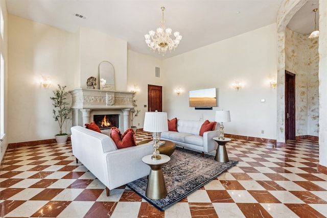 living room featuring a notable chandelier, a high end fireplace, and high vaulted ceiling