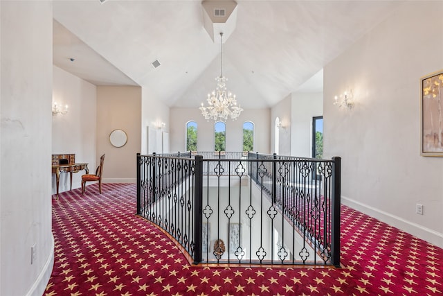 corridor featuring lofted ceiling, a chandelier, and carpet flooring