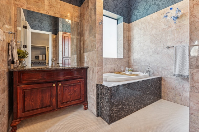 bathroom featuring vanity, tile walls, a tub, and tile patterned floors