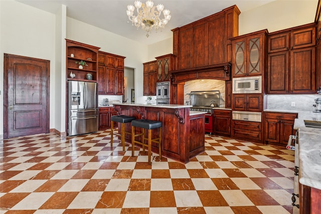 kitchen with tasteful backsplash, a breakfast bar, a chandelier, stainless steel appliances, and a center island