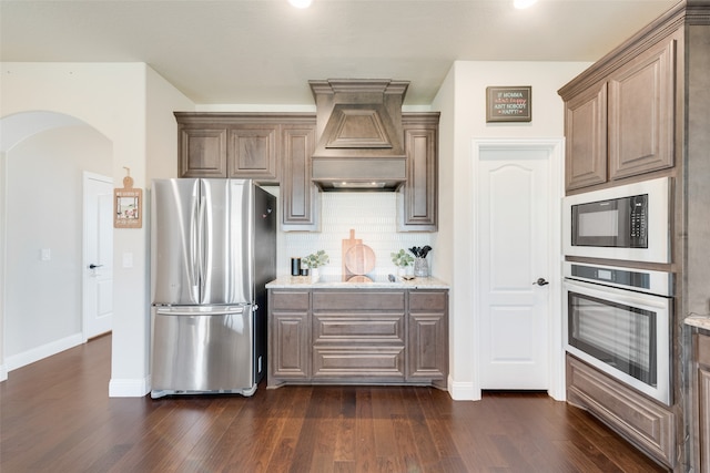 kitchen featuring black appliances, premium range hood, backsplash, and dark hardwood / wood-style flooring