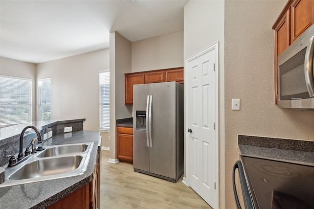 kitchen with light hardwood / wood-style flooring, stainless steel appliances, and sink