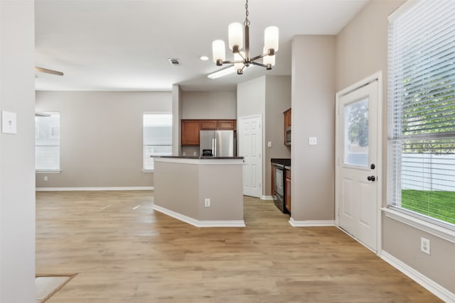 kitchen with appliances with stainless steel finishes, light hardwood / wood-style flooring, hanging light fixtures, and ceiling fan with notable chandelier