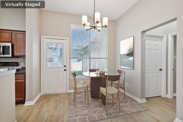 dining room with an inviting chandelier and light hardwood / wood-style flooring