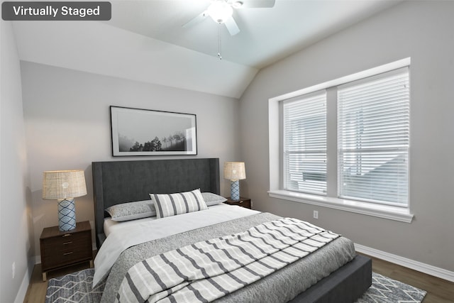 bedroom with dark wood-type flooring, vaulted ceiling, and ceiling fan