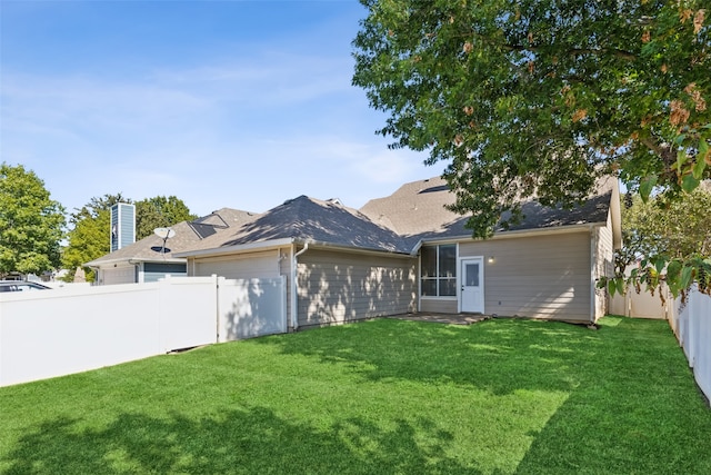 rear view of house featuring a lawn