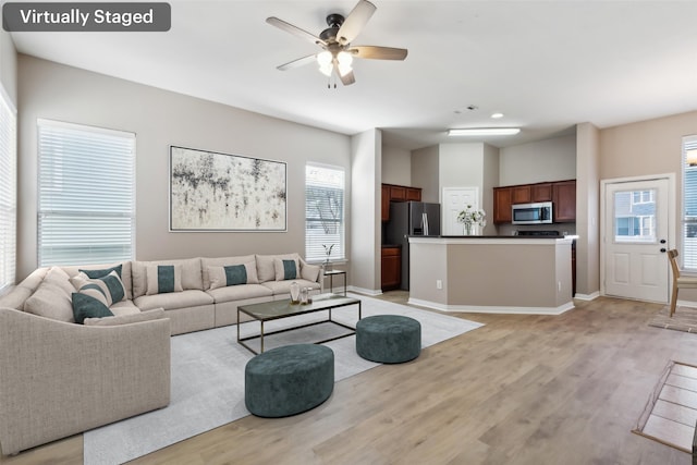 living room with ceiling fan and light hardwood / wood-style flooring