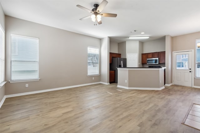 kitchen with ceiling fan, stainless steel appliances, and light hardwood / wood-style flooring