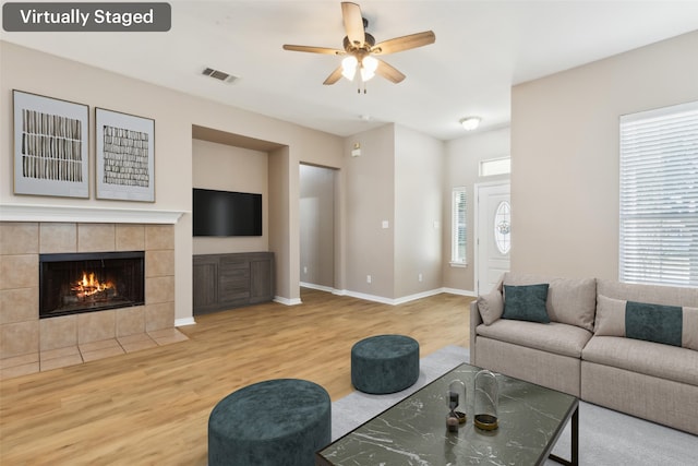 living room featuring a healthy amount of sunlight, wood-type flooring, and ceiling fan