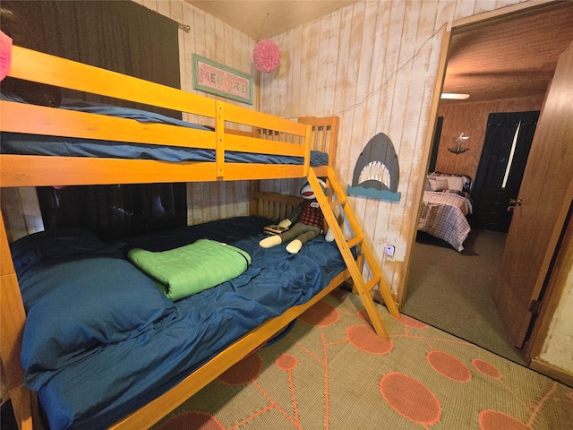 bedroom with carpet flooring and wood walls