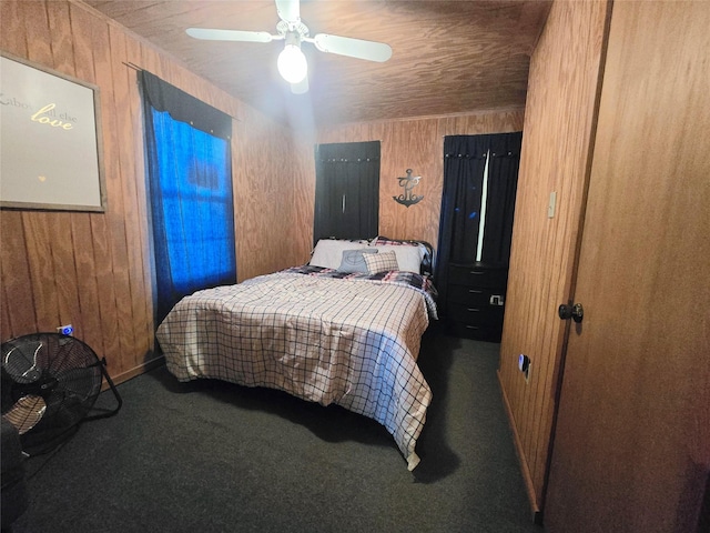 carpeted bedroom with ceiling fan, wooden ceiling, and wood walls