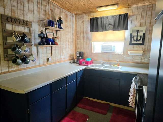 kitchen featuring wood walls, range, sink, and a wall mounted AC