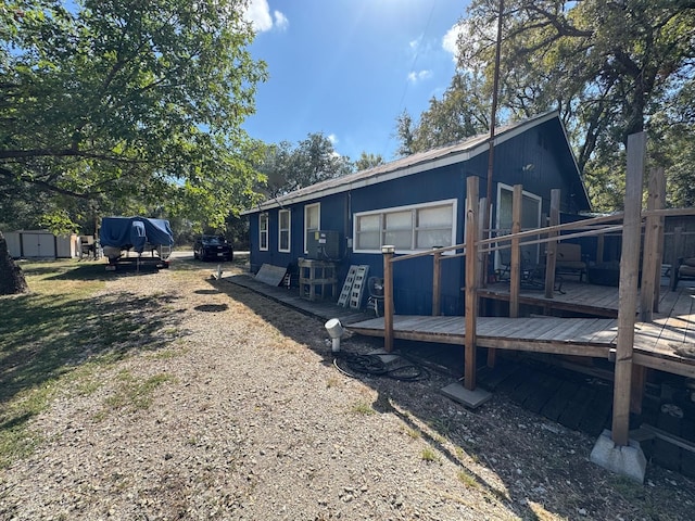 view of side of property featuring a shed and a wooden deck