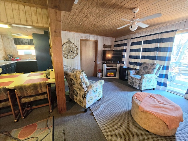 living room featuring ceiling fan, wooden ceiling, and wooden walls