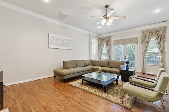 living room featuring crown molding, light hardwood / wood-style flooring, and ceiling fan