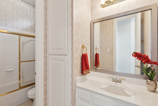 full bathroom featuring vanity, toilet, and shower / bath combination with glass door