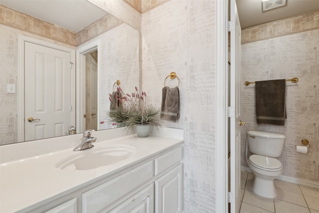 bathroom with toilet, vanity, and tile patterned flooring