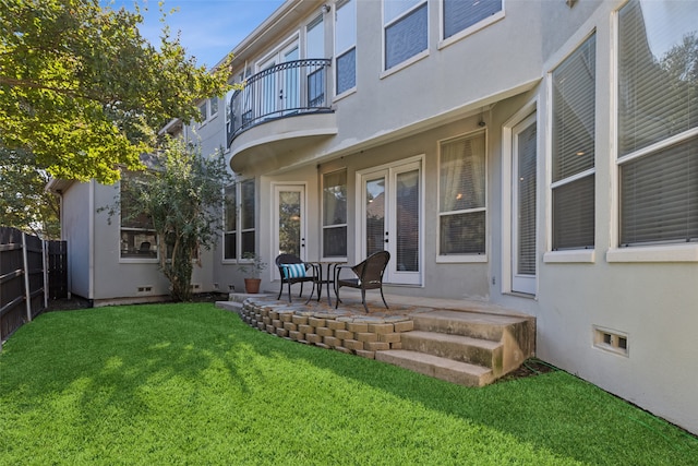 back of house featuring a patio, a lawn, and a balcony