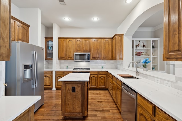 kitchen with sink, appliances with stainless steel finishes, a center island, and dark hardwood / wood-style floors