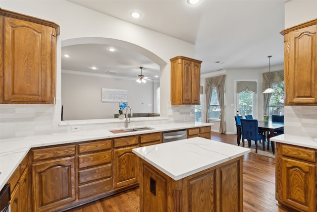 kitchen featuring tasteful backsplash, sink, a center island, dark hardwood / wood-style flooring, and stainless steel dishwasher