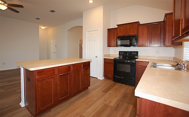 kitchen with a kitchen island, light hardwood / wood-style flooring, sink, black appliances, and ceiling fan