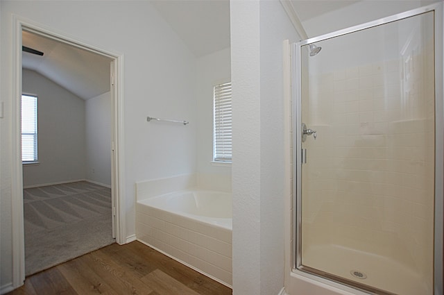 bathroom featuring hardwood / wood-style flooring, independent shower and bath, and vaulted ceiling