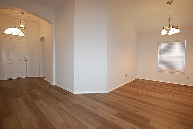 foyer entrance with crown molding, vaulted ceiling, a chandelier, and dark hardwood / wood-style flooring