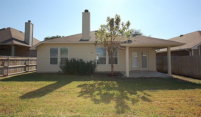 rear view of property featuring a patio area and a lawn