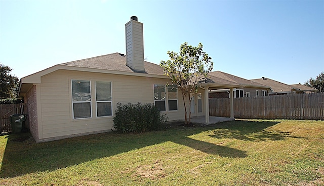 rear view of house featuring a yard and a patio