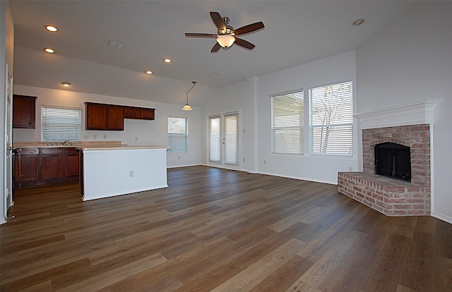 unfurnished living room featuring dark wood-type flooring, ceiling fan, a healthy amount of sunlight, and vaulted ceiling