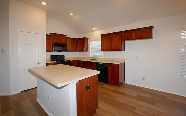 kitchen featuring a center island, a healthy amount of sunlight, black appliances, and lofted ceiling