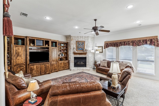 living room with light carpet, ornamental molding, a fireplace, and ceiling fan