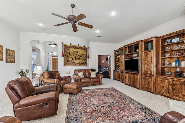 carpeted living room featuring ceiling fan and ornamental molding