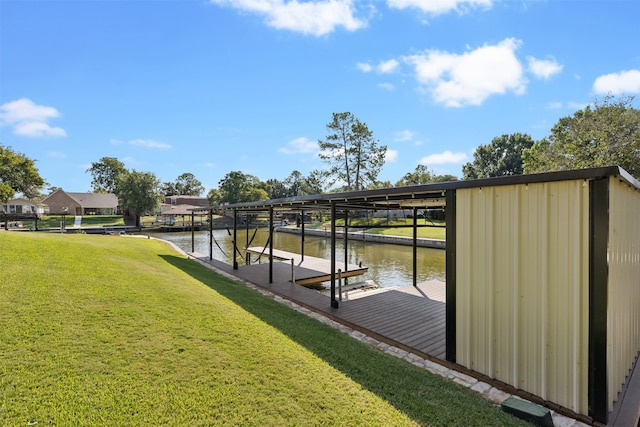 view of dock with a yard and a water view